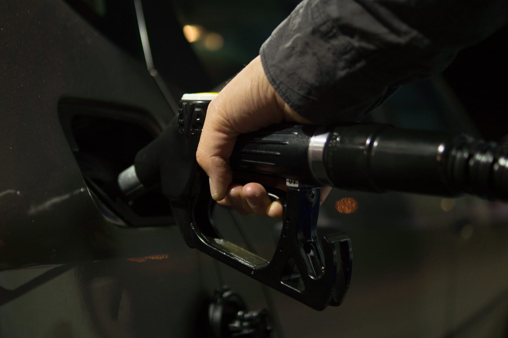 A person is filling up a car with gas at a gas station.